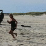 Woman Face Plants in Sand at Beach